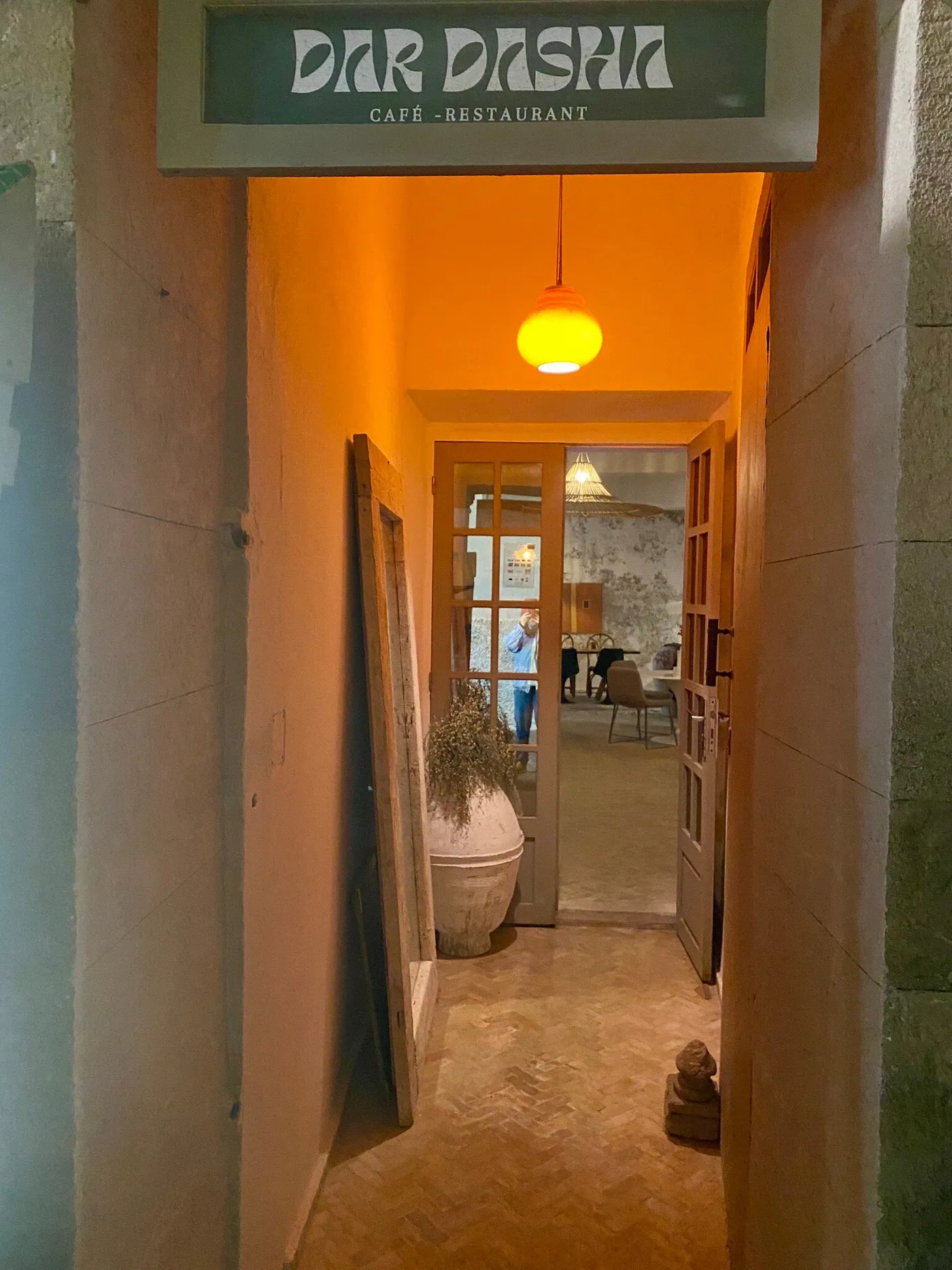 Warm lamplit corridor into the dining room